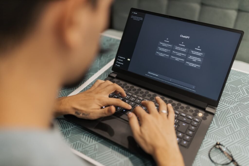 Person typing on a laptop with the ChatGPT interface open, illustrating how companies earn ChatGPT citations for B2B buyer research