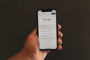 Hand holding smartphone with Google search open, illustrating how patients use Google AI Overviews to find med spa services