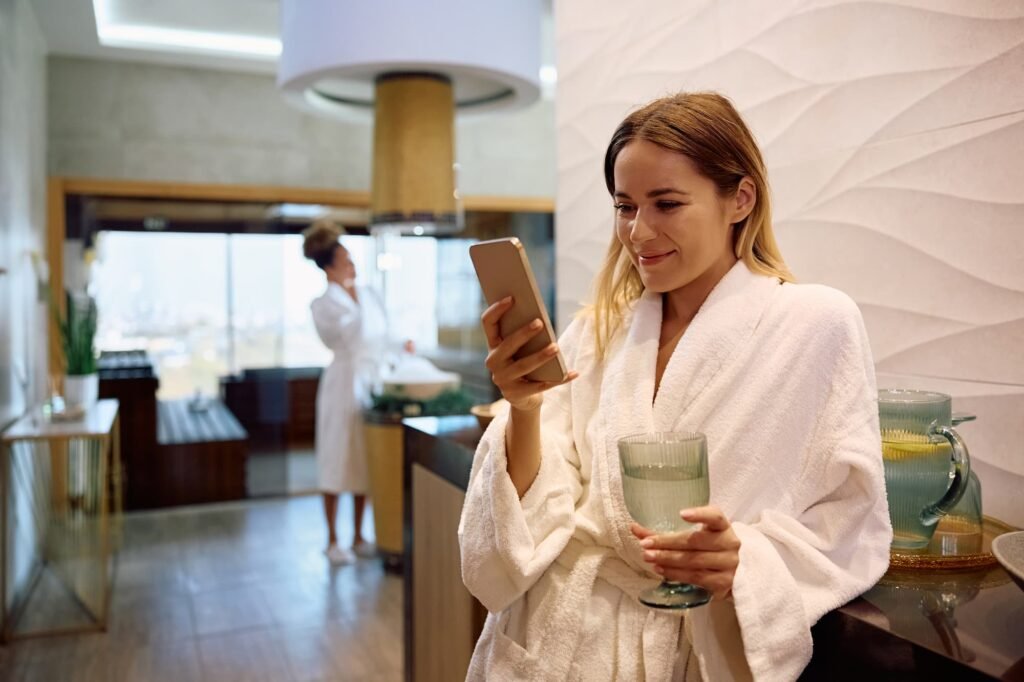 Woman in spa robe using smartphone to search for a med spa, illustrating how AI search visibility determines which clinic patients find first