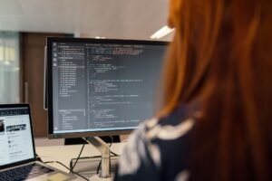 Person reviewing a code editor displaying JavaScript functions and structured configuration objects, illustrating the technical side of schema markup for B2B websites
